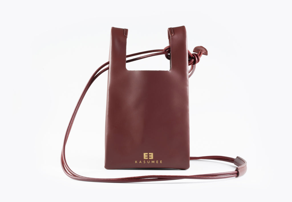 Burgundy leather crossbody bag on a white background