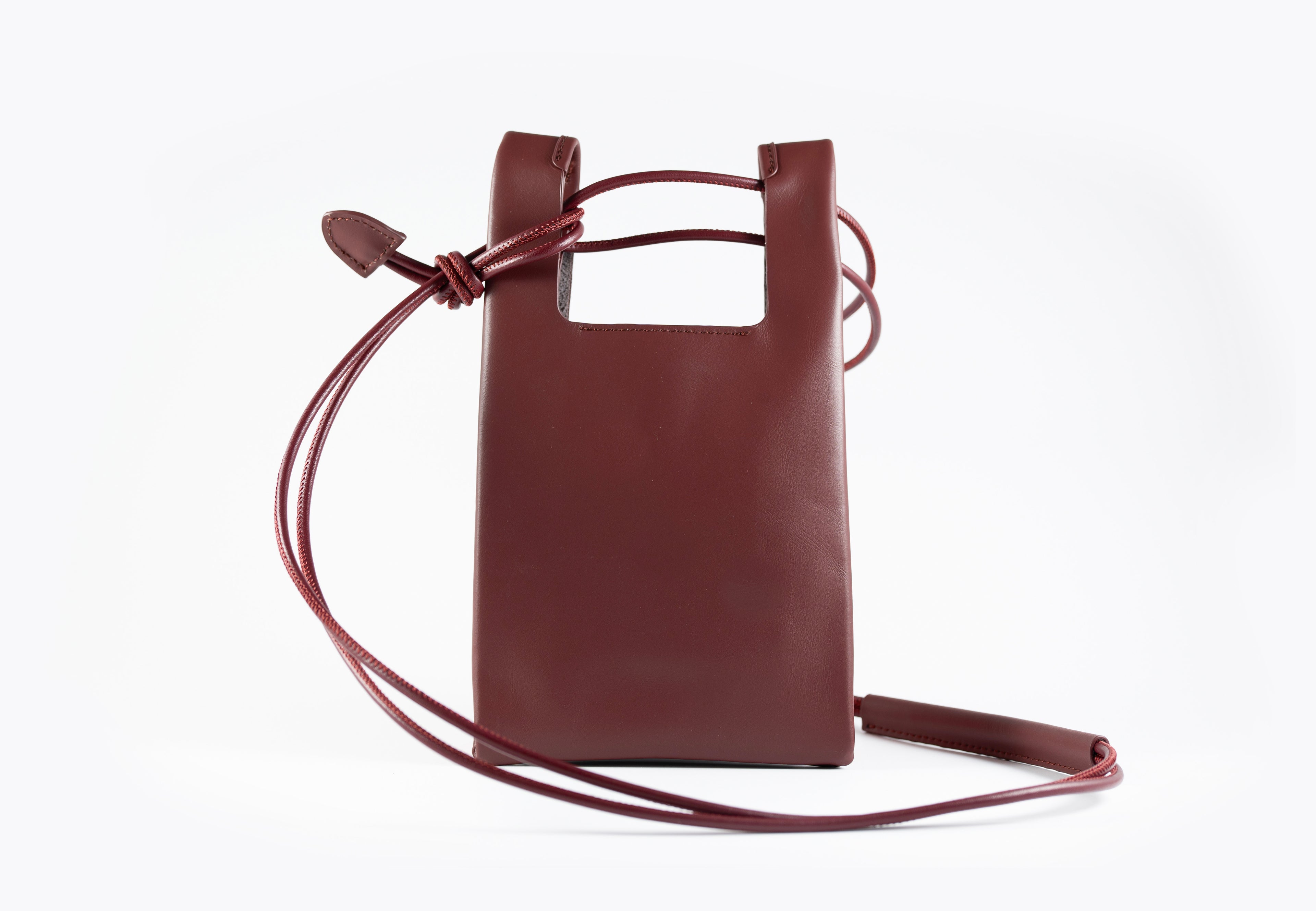Burgundy leather crossbody bag on a white background
