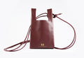Burgundy large leather crossbody phone bag by KASUMEE, front view with gold logo and long thin leather strap